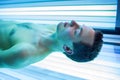 Handsome young man relaxing in a modern solarium