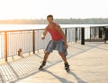 Handsome young man roller skating on pier Royalty Free Stock Photo