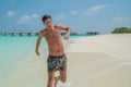 Handsome young man running near ocean at tropical beach in island luxury resort Royalty Free Stock Photo