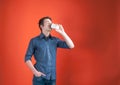 Handsome young man in shirt with rolled sleeves drinking coffee with paper cup, holding hand in pocket and looking away Royalty Free Stock Photo