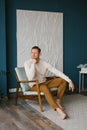 Handsome young man sitting in armchair indoors Royalty Free Stock Photo