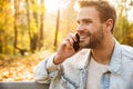 Handsome young man sitting on a bench in the autumn park Royalty Free Stock Photo