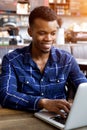 Handsome young man sitting in cafe working on laptop Royalty Free Stock Photo