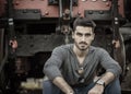 Handsome young man sitting in front of old train Royalty Free Stock Photo