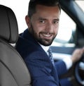 Handsome young man sitting in the front seat of a car looking at the camera Royalty Free Stock Photo