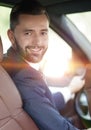 Handsome young man sitting in the front seat of a car looking at the camera Royalty Free Stock Photo
