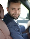 Handsome young man sitting in the front seat of a car looking at the camera Royalty Free Stock Photo