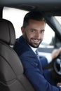 Handsome young man sitting in the front seat of a car looking at the camera Royalty Free Stock Photo