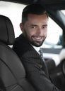 Handsome young man sitting in the front seat of a car looking at the camera Royalty Free Stock Photo