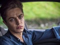 Handsome young man sitting in his car, looking at camera Royalty Free Stock Photo