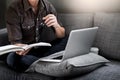 Handsome Young Man Sitting on the Living Room Couch, Casual young man reading documents on sofa at home