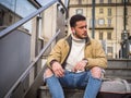 Handsome young man sitting on stairs