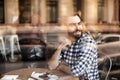 Handsome young man sitting at table in cafe, view from outdoors Royalty Free Stock Photo