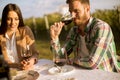 Handsome young man sitting by the table and drinking red wine in the vineyard Royalty Free Stock Photo