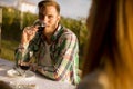 Handsome young man sitting by the table and drinking red wine in the vineyard Royalty Free Stock Photo