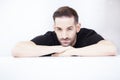 Handsome young man sitting at the table and looking at camera Royalty Free Stock Photo