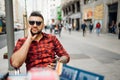 Handsome young man sitting in urban cafe on the busy street in Madrid, Spain. Good looking spanish man portrait in urban setting Royalty Free Stock Photo