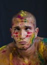 Handsome young man with skin all painted with Holi colors Royalty Free Stock Photo