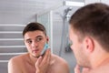 Handsome young man smearing shaving gel on his face Royalty Free Stock Photo