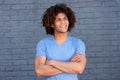 Handsome young man smiling with arms crossed against gray wall Royalty Free Stock Photo