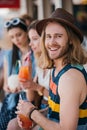 handsome young man smiling at camera while drinking cocktail with friends Royalty Free Stock Photo