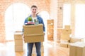 Handsome young man smiling happy moving to a new home, very excited holding cardboard boxes at new apartment Royalty Free Stock Photo