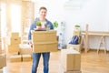 Handsome young man smiling happy moving to a new home, very excited holding cardboard boxes at new apartment Royalty Free Stock Photo