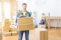 Handsome young man smiling happy moving to a new home, very excited holding cardboard boxes at new apartment Royalty Free Stock Photo