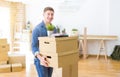 Handsome young man smiling happy moving to a new home, very excited holding cardboard boxes at new apartment Royalty Free Stock Photo