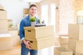 Handsome young man smiling happy moving to a new home, very excited holding cardboard boxes at new apartment Royalty Free Stock Photo