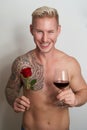 Male lover smiling with a flower and a glass of wine