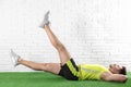 Handsome young man in sportswear doing scissors exercise on artificial green lawn Royalty Free Stock Photo