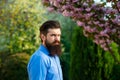 Handsome young man on spring nature background looking at camera. Male model Enjoying Nature. Romantic beauty in fantasy Royalty Free Stock Photo