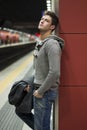 Handsome young man standing against wall in train or subway station Royalty Free Stock Photo