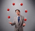 Young man standing and juggling with red balls Royalty Free Stock Photo