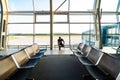 Handsome young man talking on the phone is standing near the panoramic window in airport terminal while waiting for the flight Royalty Free Stock Photo