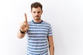 Handsome young man standing over isolated background pointing with finger up and angry expression, showing no gesture Royalty Free Stock Photo