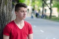 Handsome young man standing beside tree outdoor in spring Royalty Free Stock Photo