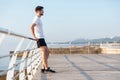 Handsome young man standing on wooden terrace near the sea Royalty Free Stock Photo