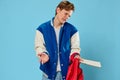 a handsome young man student with red hair stands in a fashionable jacket sadly spreading his arms holding a backpack Royalty Free Stock Photo