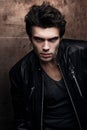 Handsome young man in stylish black leather jacket. Fashion model in dark clothes Royalty Free Stock Photo