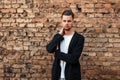 Handsome young man in stylish business clothes near a brick wall. Royalty Free Stock Photo