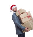 Handsome young man in a suit wearing Christmas hat holding a pile of presents Royalty Free Stock Photo