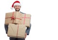 Handsome young man in a suit wearing Christmas hat holding a pile of presents Royalty Free Stock Photo