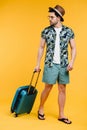 handsome young man in summer outfit holding suitcase and looking away Royalty Free Stock Photo