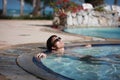 Handsome young man in sunglasses lays in swimming pool resting. happiness, summer travel vacations hotel. Royalty Free Stock Photo