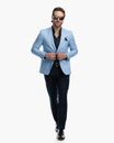 handsome young man with sunglasses walking and closing his suit Royalty Free Stock Photo