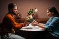 Handsome young man talking congratulatory speech and giving box with gift to girlfriend on birthday or Valentines Day. Royalty Free Stock Photo