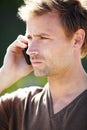 Keeping in touch. A handsome young man talking on his cellphone with a serious expression. Royalty Free Stock Photo