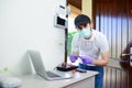 Handsome young man telephone operator worker fixing internet issue connexion at client house with surgical mask and gloves COVID19 Royalty Free Stock Photo